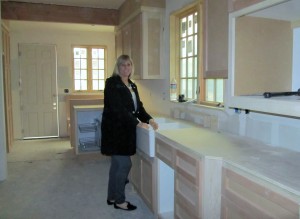 Sharon anxiously awaiting her functional gourmet kitchen.  Check out the farm-style sink.  Awesome.